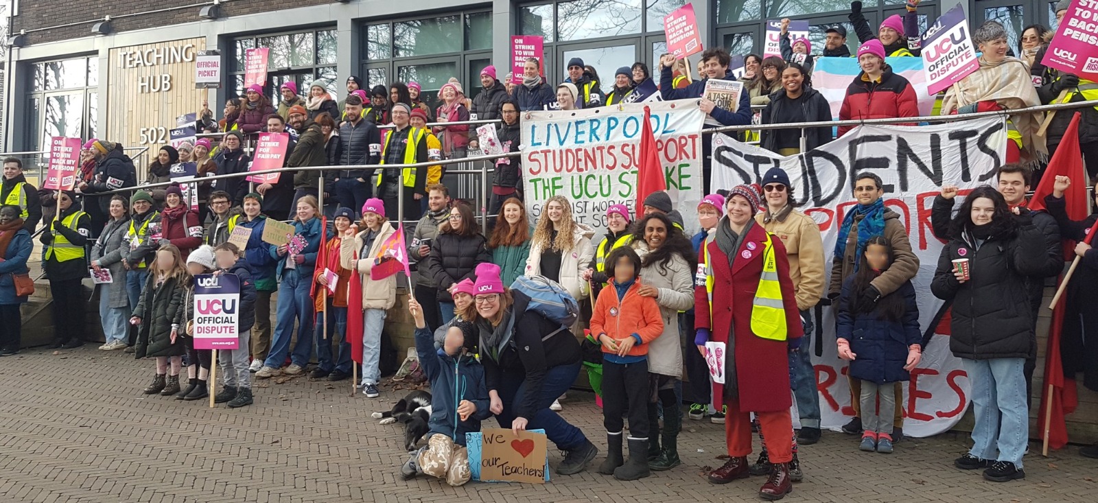 UCU members gather for a photo outside teaching hub 502. There are lots of them! Students hold up a banner reading 'Liverpool students support the UCU strike'.